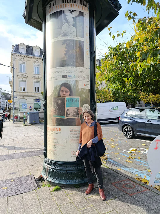 Photographie de Rita Azevedo Gomes devant l'affiche de la Semaine Rohmer 2025