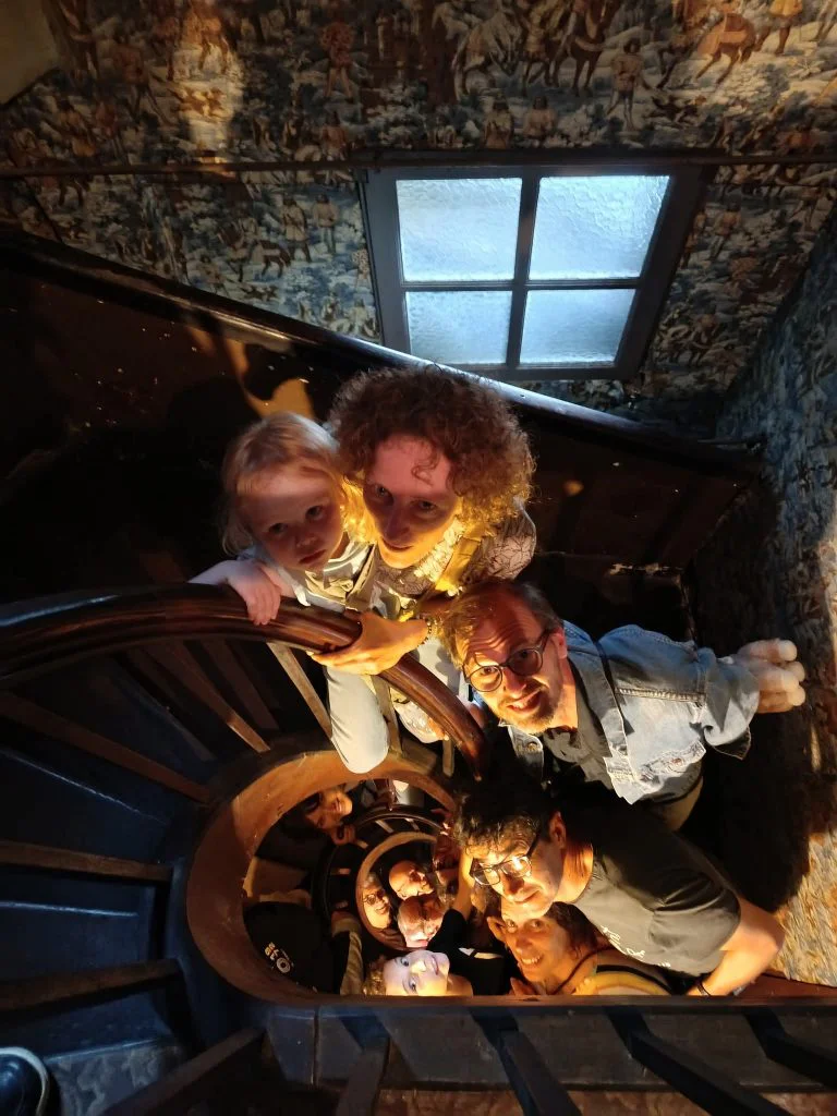 Photographie d'un groupe de visiteurs déambulant dans l'escalier en colimaçon de la maison.
